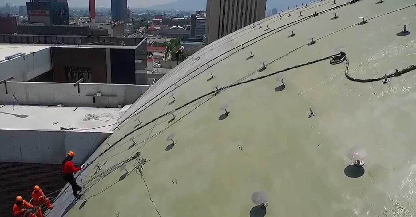 Contractor spray-applying a polyurea roof coating